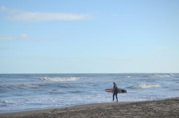 Fototapeta na wymiar Surfista entrando al mar a la tarde