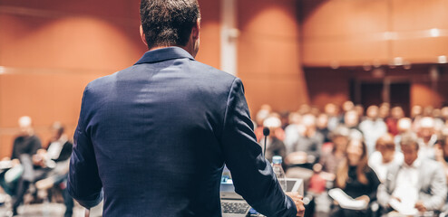 Public speaker giving talk at Business Event.