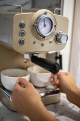 Female hands holding two white porcelain cups cooking fragrance aroma morning coffee in machine