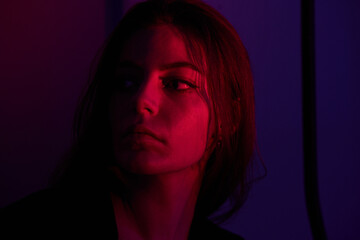 Half-lighted face of girl with blueish and very peri background