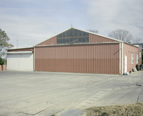 A closeup shot of a red barn under the blue sky