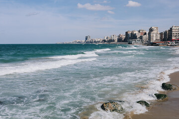 Old city direct at sea, beach harbor with stones and buildings in Alexandria, Egypt