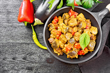 Meat with eggplant and pepper in pan on board top