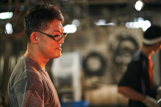 溶解炉を覗き込むガラス職人