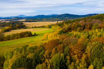 Aerial view of picturesque autumn hilly landscape with colored trees..