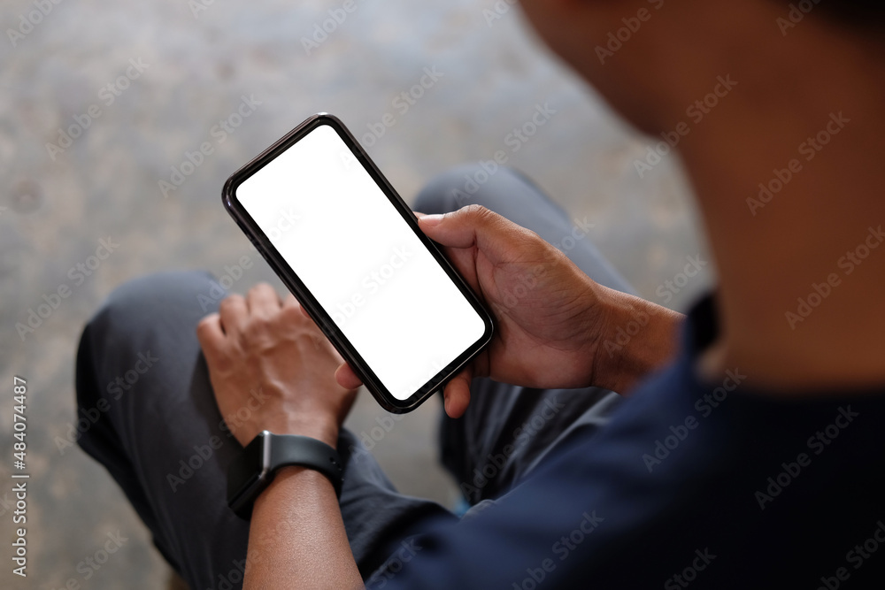 Poster young man holding mockup smart phone with empty screen. close up..