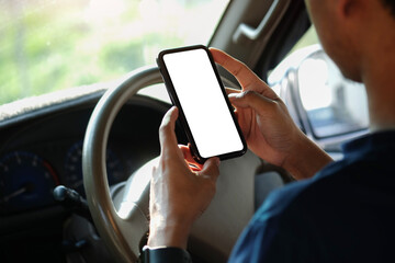 Close up view businessman sitting in car and using smart phone. Blank screen for your advertising text.