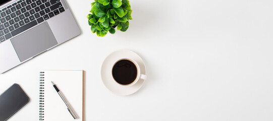 Laptop and coffee cup on a white table in the office. Working concept using technology,...
