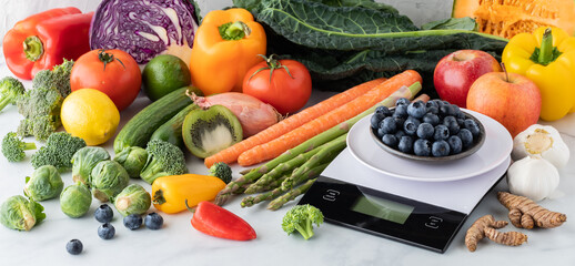 Blueberries on a food scale with a large variety of produce surrounding.