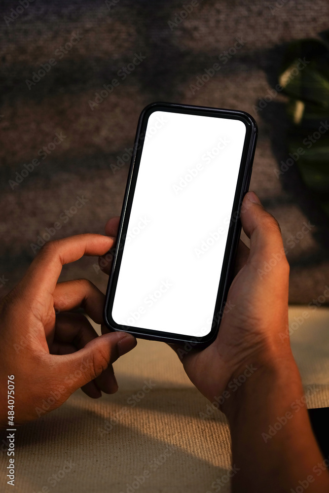 Aufkleber close up view man holding mockup mobile phone with empty screen for advertisement text.