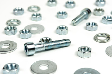 several silver metal bolts with nuts on a white background. abstract background, close-up