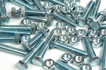 several silver metal bolts with nuts on a white background. close-up