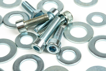 several metal washers and bolts in silver color on a white background. close-up