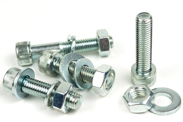 several metal washers, nuts and bolts of silver color on a white background. close-up