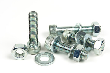 several metal washers, nuts and bolts of silver color on a white background. close-up