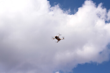 Single drone on white clouds sky on background with space