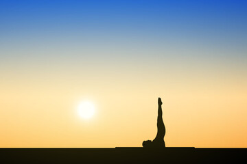 Silhouette of young people doing yoga exercises at sunset background. health concept.