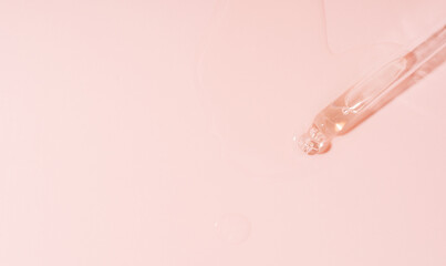 Liquid flows out of pipette on pink background.