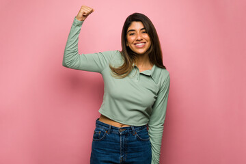 Young woman showing her strength - obrazy, fototapety, plakaty