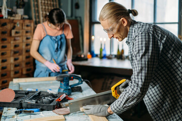 Man and woman working in workshop, doing furniture, reuse old materials to new product. awareness in consumption. Small family business. Recycling, sustainability refurbishments maintenance for home