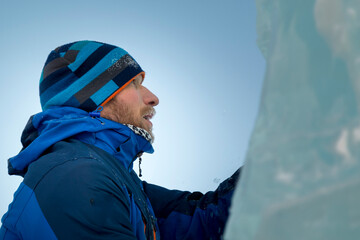 Portrait of a builder in a blue knitted hat and blue winter jacket