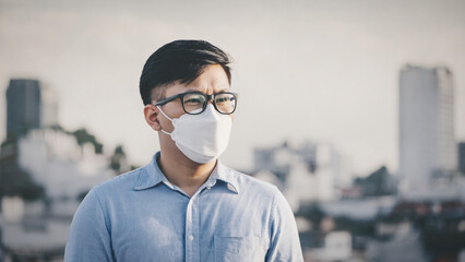 Man wearing N95 PM 2.5 the respiratory protection mask against air pollution and dust particles exceed the safety limits. Healthcare, environmental, ecology concept. Allergy, headache.