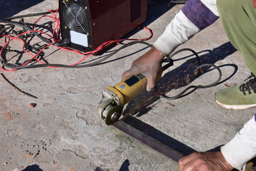 Metal cutting with a handheld machine with a cutting disc. Construction works. Hand Tools.