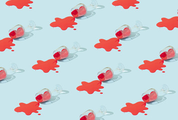 Pattern made of champagne glass and red paint on a pastel blue background. Holiday minimal concept.