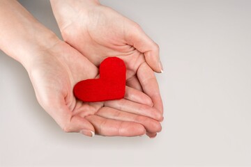 Person holding white heart in palm. Organ donation and insurance concept.