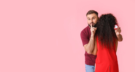 Young man proposing to his girlfriend on pink background with space for text