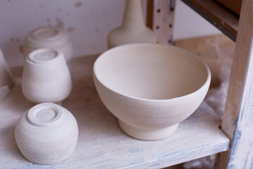 Fototapeta na wymiar Empty handmade dishes. ceramic bowls on the shelf. Handmade work. The plates are made of clay