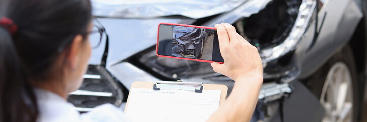 Insurance agent takes pictures of damage to car after accident on smartphone - obrazy, fototapety, plakaty