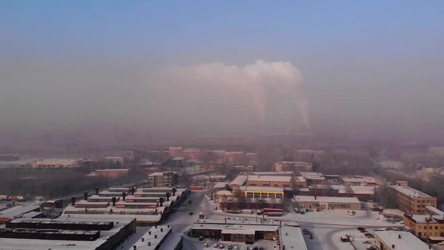 Metallurgical plant with working pipes in the city of Novokuznetsk, Kemerovo region. Industrial city top view from an unmanned aerial vehicle. Bad environment, thick smog in the sky.
