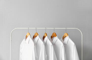 Rack with clean shirts on grey background
