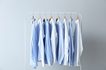 Rack with clean shirts on grey background