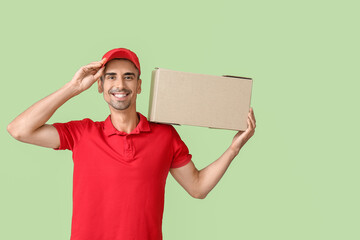 Male courier with parcel on color background