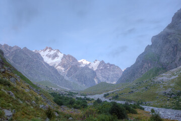 Mountain valley with snowy mountain peaks against the background of the evening sky. selective focus on mountains.