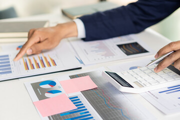 Businessman working with financial graph and calculator with the pen to analyze home expense account data.