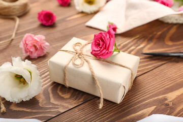 Obraz na płótnie Canvas Gift box with rope and roses on dark wooden background, closeup