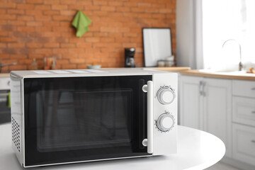 Microwave oven on white table in stylish kitchen