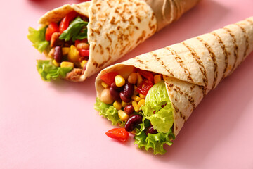 Delicious burritos on pink background, closeup
