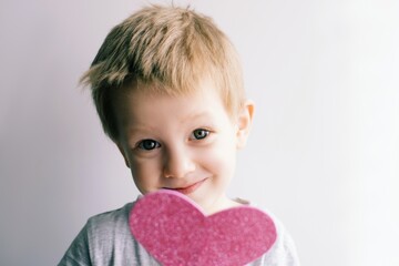 little emotional, smiling child with a pink heart - 484093824