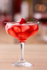 Glass of iced Manhattan cocktail on table, closeup