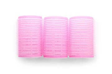 Pink hair curlers on light background