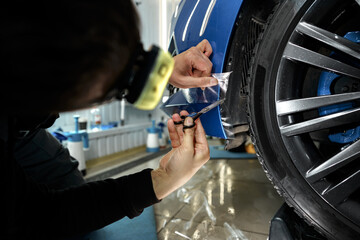 Car detailing. Man applies nano protective coating to the car in car detailing service
