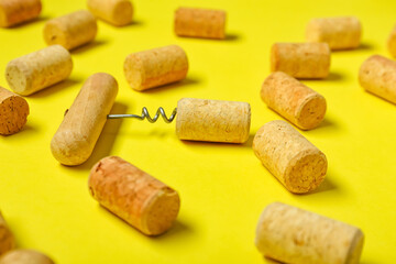 Wine corks and opener on yellow background