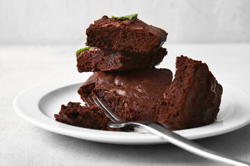 Plate with pieces of tasty chocolate brownie on table