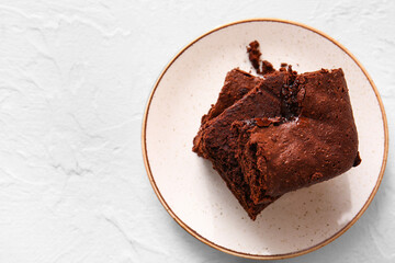 Plate with pieces of tasty chocolate brownie on white background