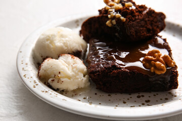 Plate with pieces of tasty chocolate brownie and ice cream on white background, closeup
