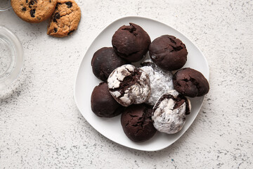 Plate with tasty brownie cookies on light grunge background